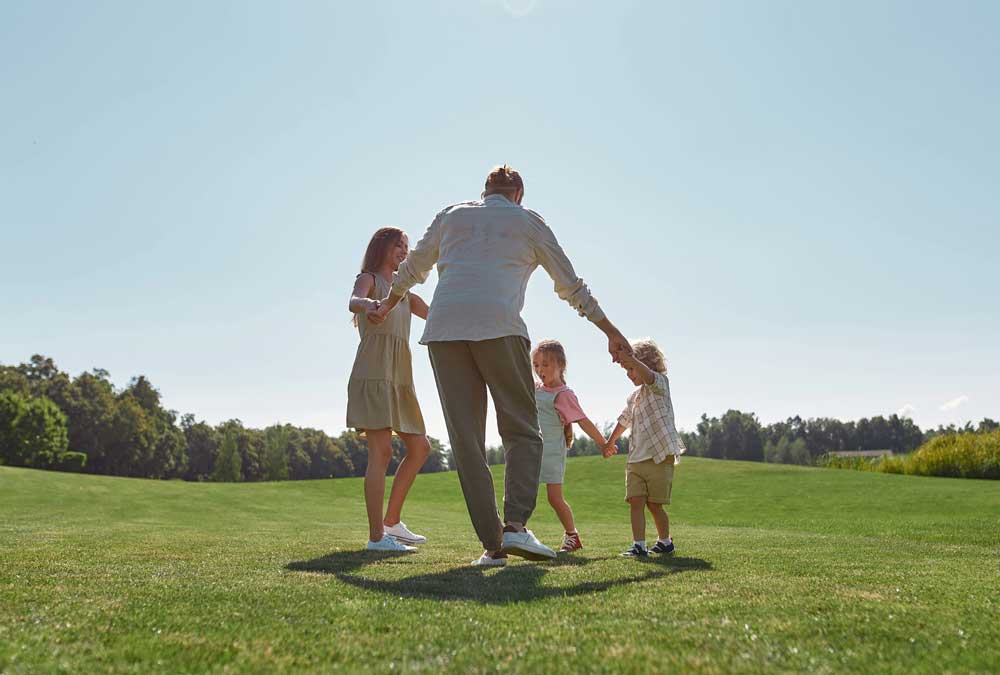 Familj som dansar på en äng