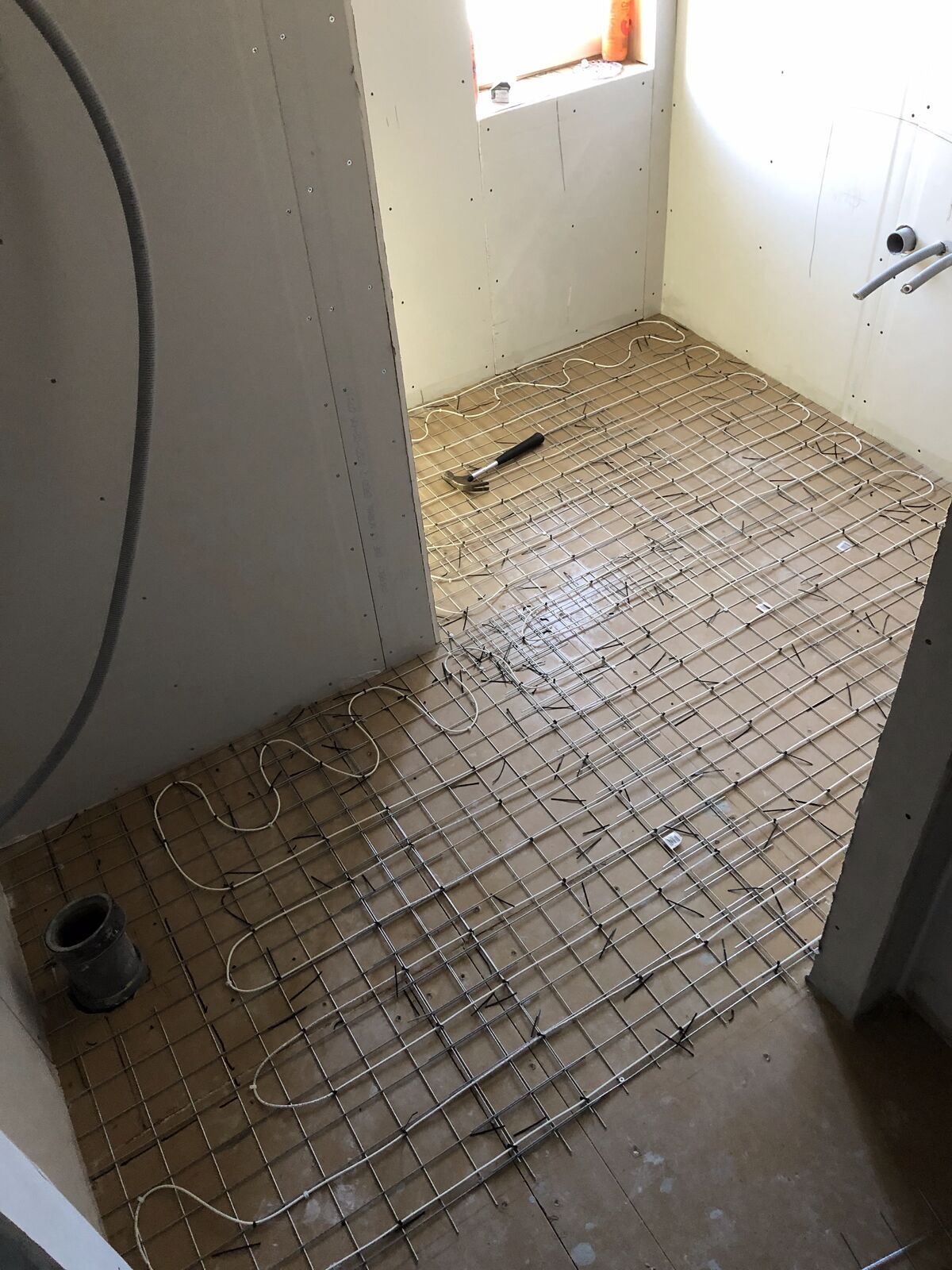 Golvvärmekabel utlagd på armeringsnät i ett badrum, Gustavsberg