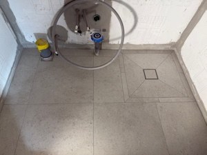 Grå klinker med fall mot golvbrunnen i duschen, Stockholm